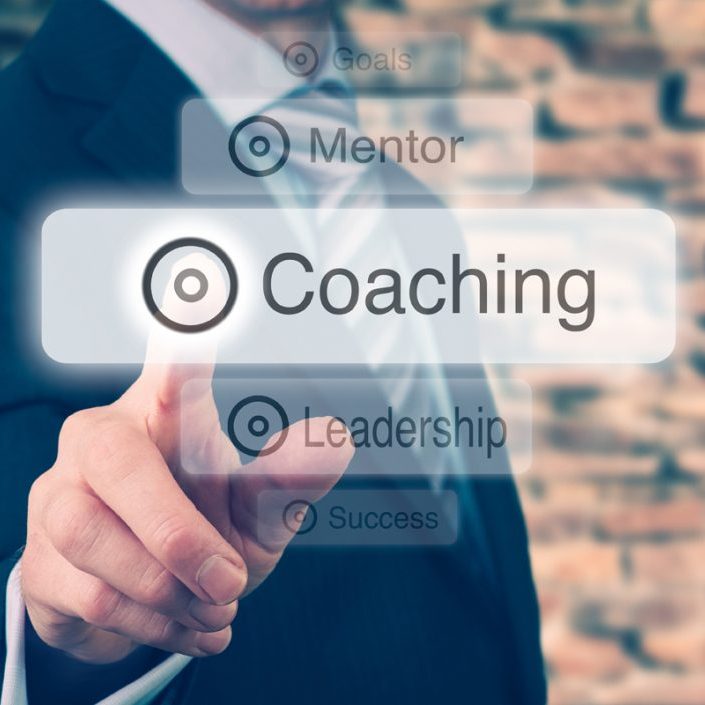 Businessman pressing a Coaching concept button.